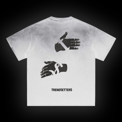 White t-shirt with black hands graphic design and 'Trendsetters' text on a dark background